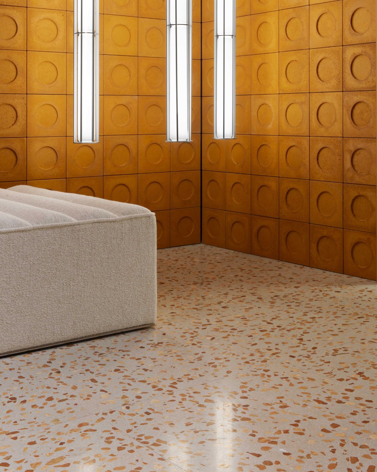 Modern room with wooden paneled walls and a textured floor.