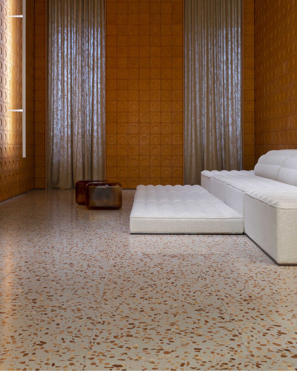 Modern living room with a white sofa and textured walls.